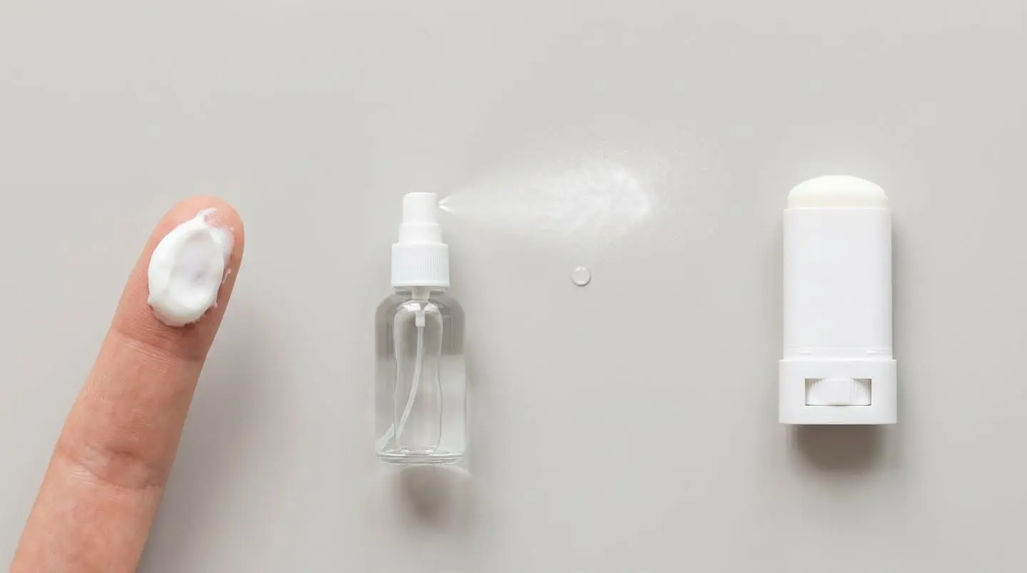 Comparaison de différentes textures de protections solaires : crème, spray et stick sur fond neutre